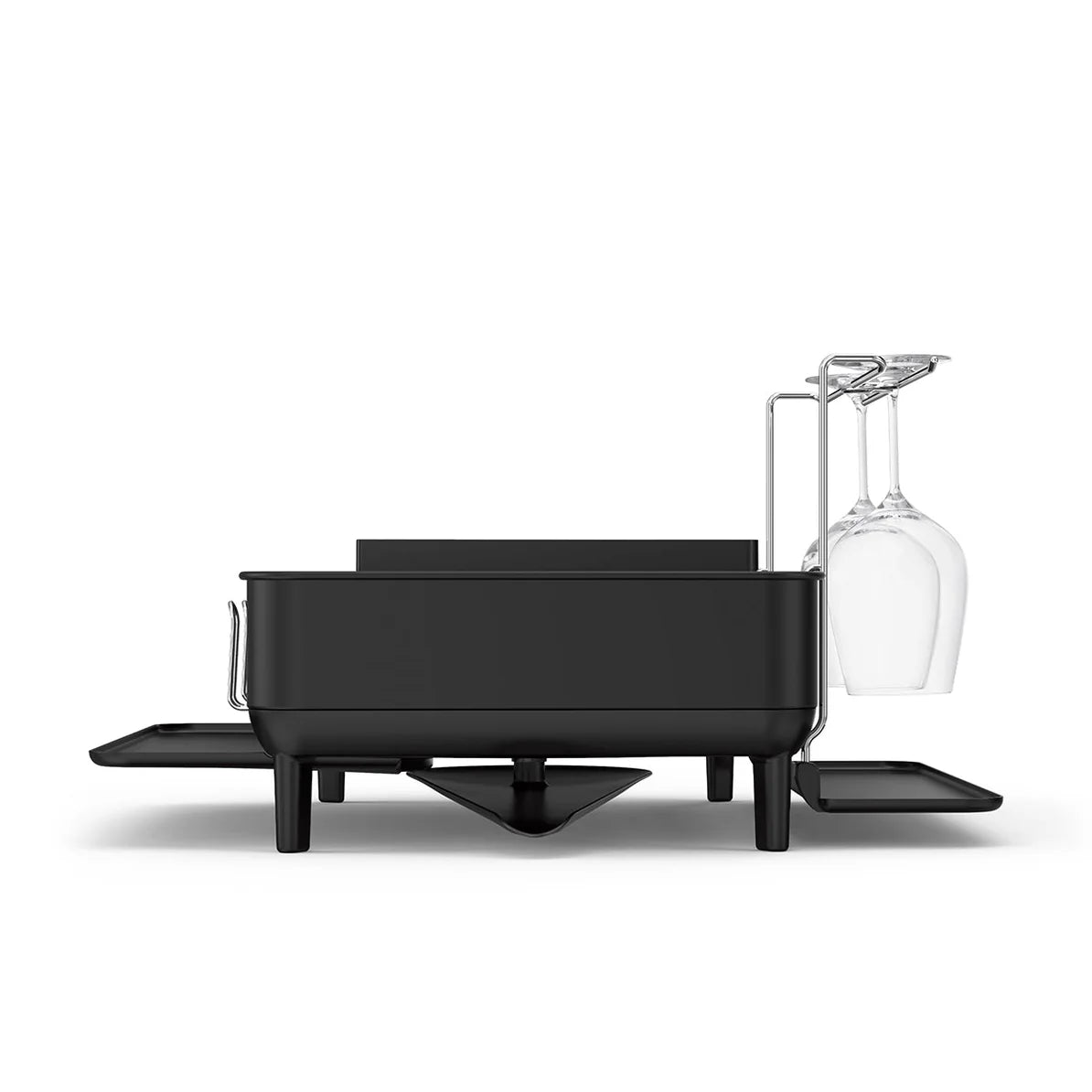 The image shows a black dish drying rack with a modern, minimalist design. The rack is elevated on legs, allowing space underneath for drainage. On one side, there is a dedicated holder for two upside-down wine glasses, demonstrating its versatility for different types of dishware. The rack features compartments for holding various kitchen items, such as plates and utensils, with side trays that can be extended for additional drying space. The sleek, all-black finish adds a contemporary touch, making it a s