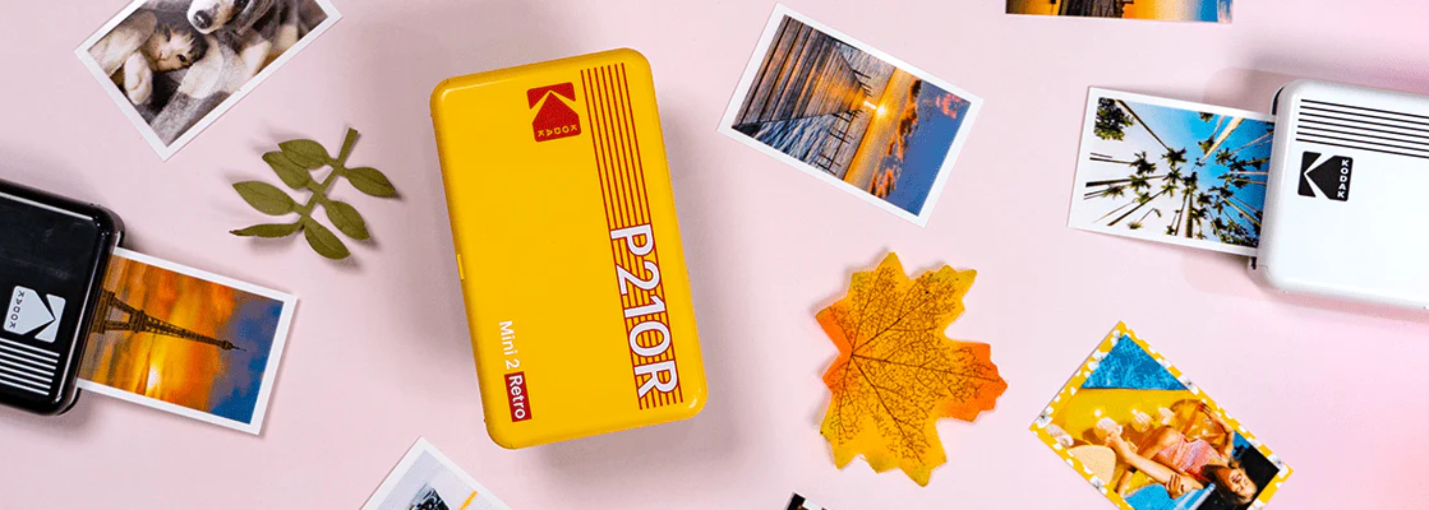 Kodak Mini 2 Retro printers in vibrant yellow and white, surrounded by colorful printed photos and decorative items, showcasing their portable design and ability to create high-quality instant prints.