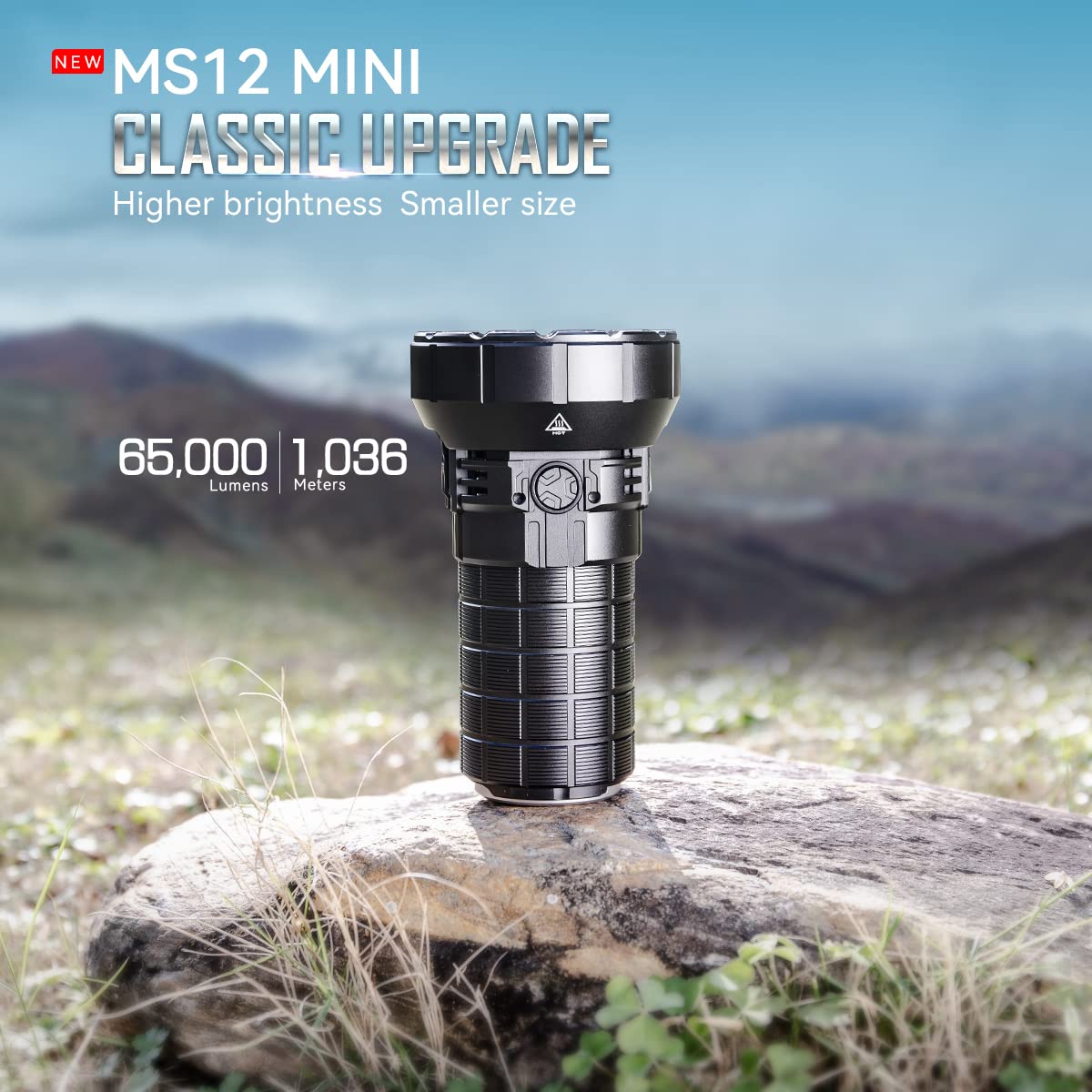 Promotional image for the IMALENT MS12 MINI flashlight, positioned outdoors on a rock with a scenic landscape in the background. The text at the top reads "NEW MS12 MINI CLASSIC UPGRADE," highlighting its features of "Higher brightness, Smaller size." The flashlight is capable of producing 65,000 lumens and has a beam distance of 1,036 meters. The flashlight's robust design is showcased, with its textured grip and large head housing multiple LED bulbs.