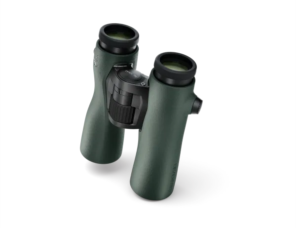 An angled view of Swarovski Optik binoculars, highlighting their sleek green finish, ergonomic build, and central focus wheel for precise adjustments.