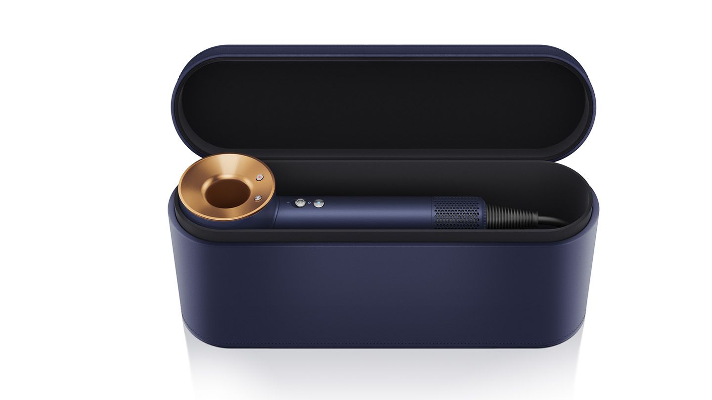 This image shows a navy and gold hairdryer elegantly placed inside a sleek, matching navy storage case. The case has a minimalist, premium design, ideal for protecting and storing the hairdryer securely while complementing its stylish look.