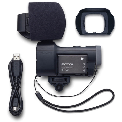 Zoom Q8 handy video recorder with included accessories such as a USB cable, foam windscreen, and lens hood.