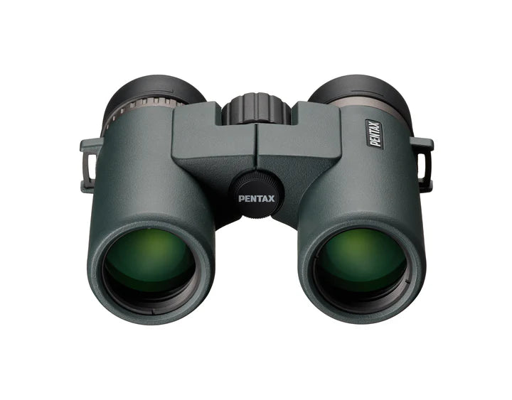 A front view of Ricoh Pentax AD 10x32 ED binoculars showing the large objective lenses with a greenish tint. The central hinge and focusing wheel are visible between the two barrels, with the Pentax branding on the right barrel. The binoculars have a robust, ergonomic design with a matte finish, emphasizing durability and high-quality optics for an enhanced viewing experience.