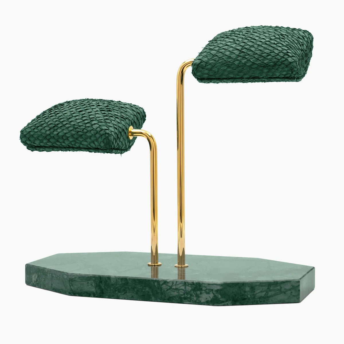 A display stand featuring two green textured cushions mounted on elegant gold curved supports. The base of the stand is a green marble slab with an irregular shape. The design is sophisticated and luxurious, ideal for showcasing wristwatches or similar items. The combination of the green cushions, gold supports, and marble base creates a refined and stylish presentation. The stand is shown from a slightly angled side view.