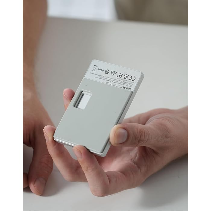 A person holding a compact SHARGE power bank in their hand, showcasing its lightweight and portable design. The back of the device displays safety certifications and product details, emphasizing its compliance and reliability for everyday use.