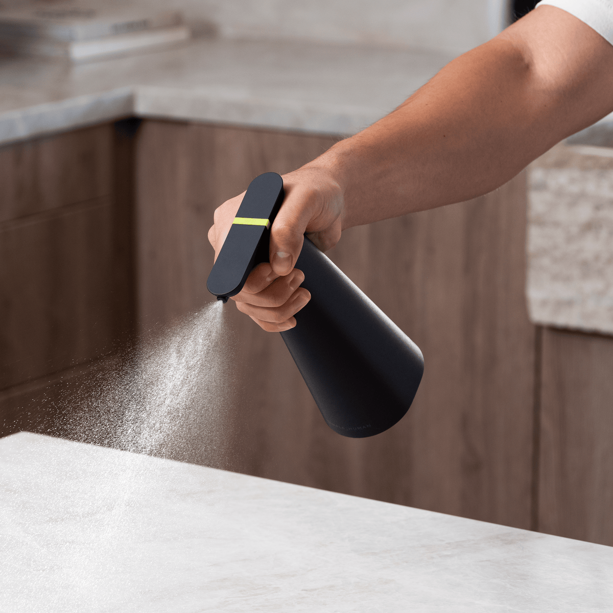 Cleaning a countertop with the black Simplehuman Sensor Spray