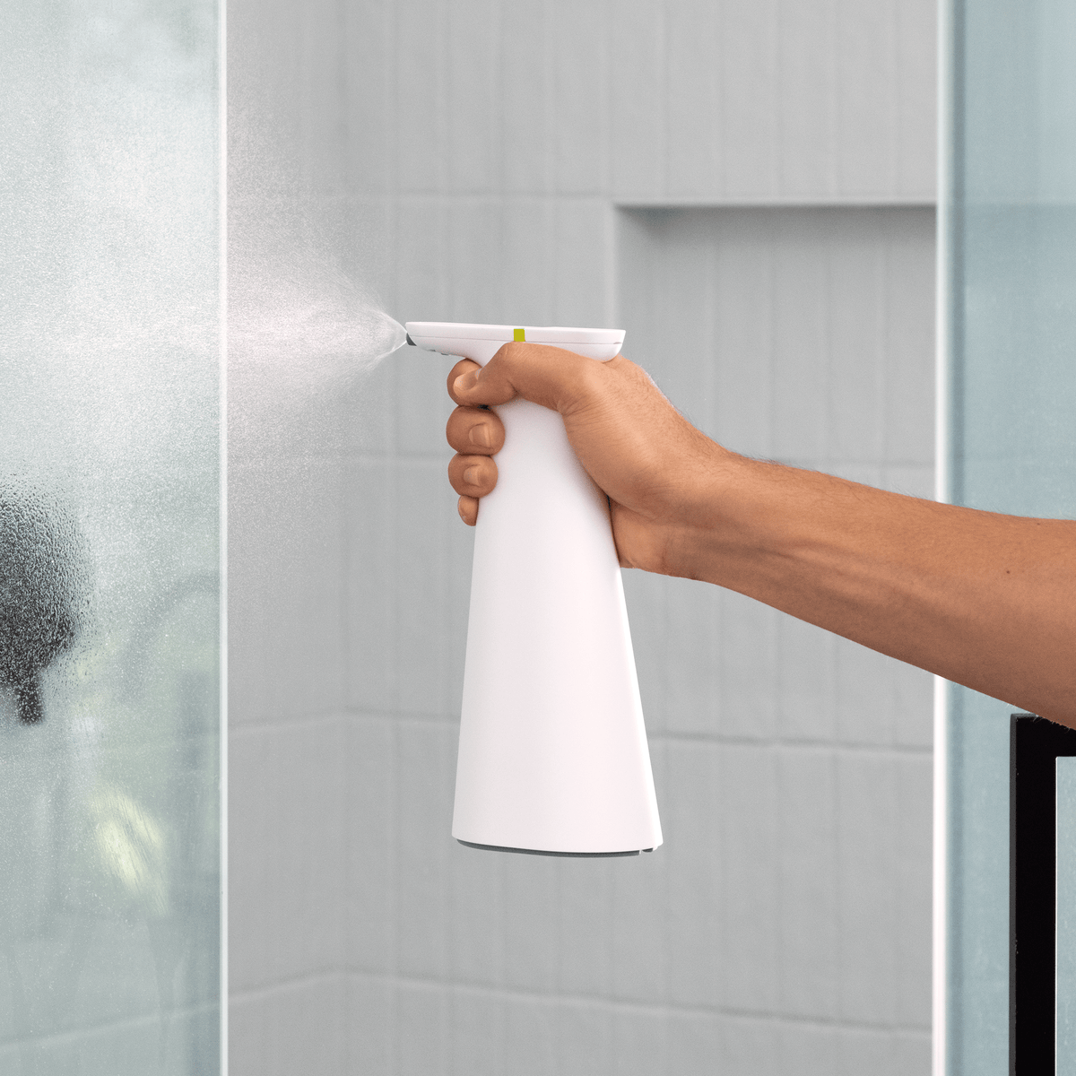 Cleaning a countertop with the white Simplehuman Sensor Spray