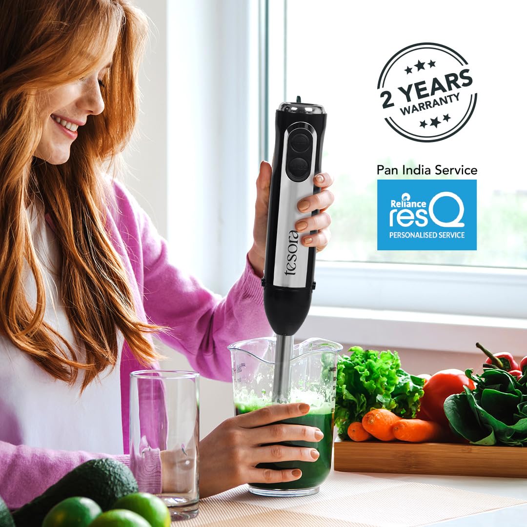 This image features a **Tesora hand blender** in use, blending a green smoothie in a measuring cup. The product highlights include:

- **2 Years Warranty**: Tesora provides a 2-year warranty for the hand blender.
- **Pan India Service**: The brand ensures service across India.
- **Reliance resQ Personalized Service**: The hand blender is supported by Reliance's personalized resQ service for product care.

The scene illustrates the product in a home kitchen setting, emphasizing the blender's efficiency for s