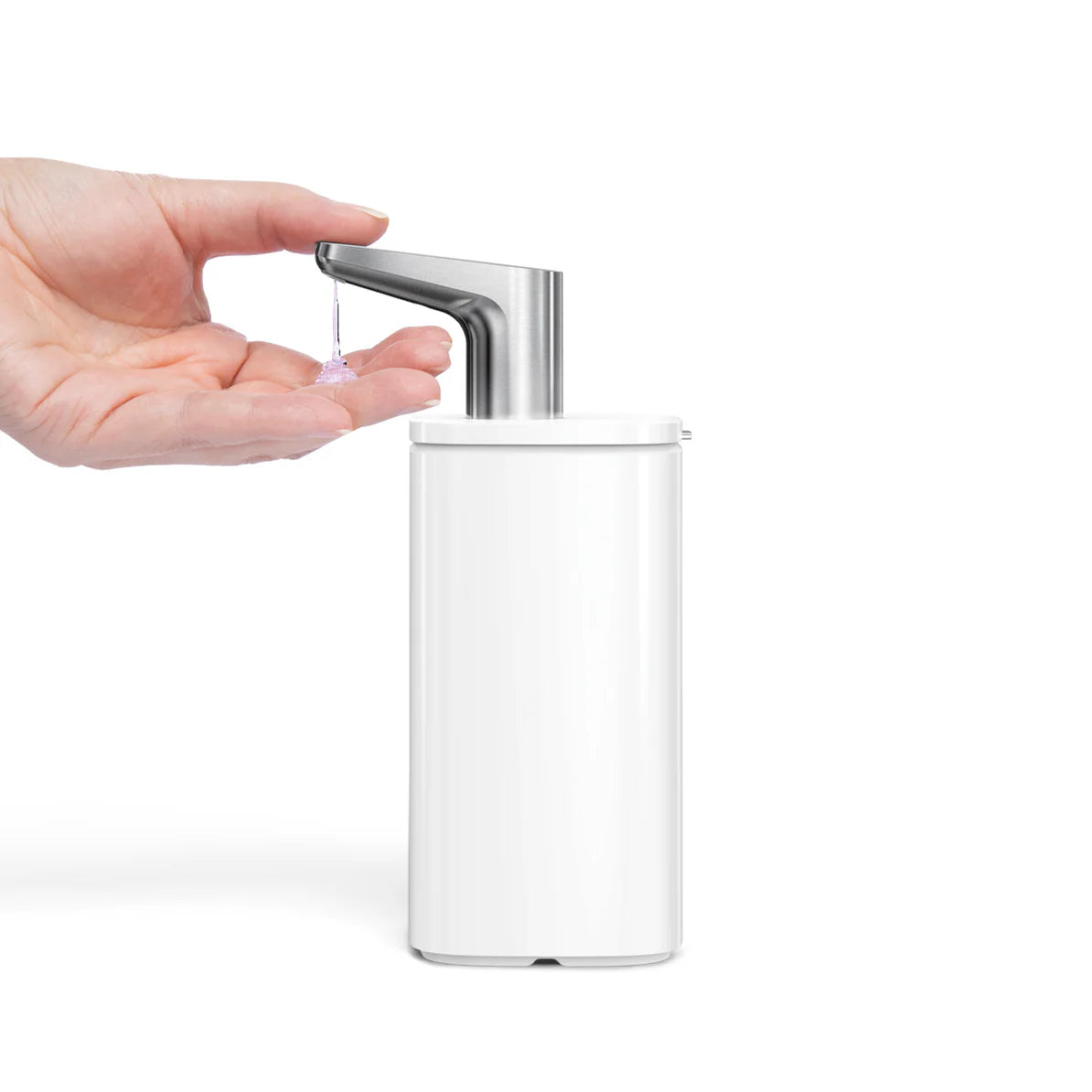 The image shows a hand positioned under the nozzle of a white automatic soap dispenser, which is dispensing soap. The dispenser has a sleek, minimalist design with a smooth, cylindrical body and a metallic nozzle that is slightly angled for easy use. The white finish gives the dispenser a clean and modern appearance, making it an attractive addition to contemporary home or commercial spaces. The design is likely from Simplehuman, known for combining functionality with elegant aesthetics.